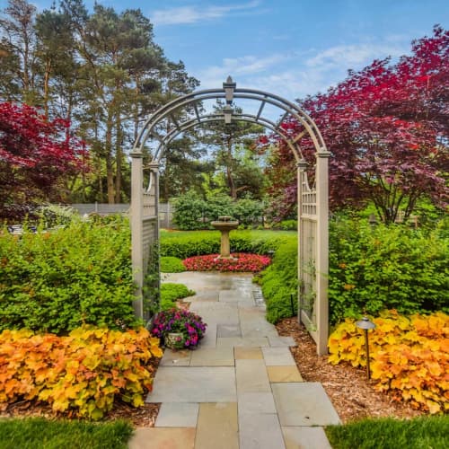 Landscape Design Services - pathway under an arbor with flowers